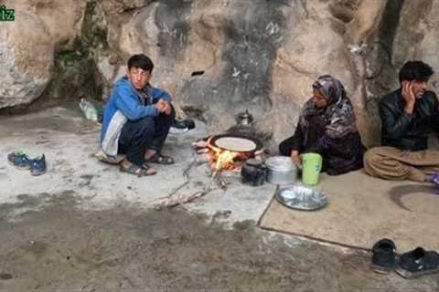 Nomadic life: preparation of traditional bread along with cooking mountain herbs with fire